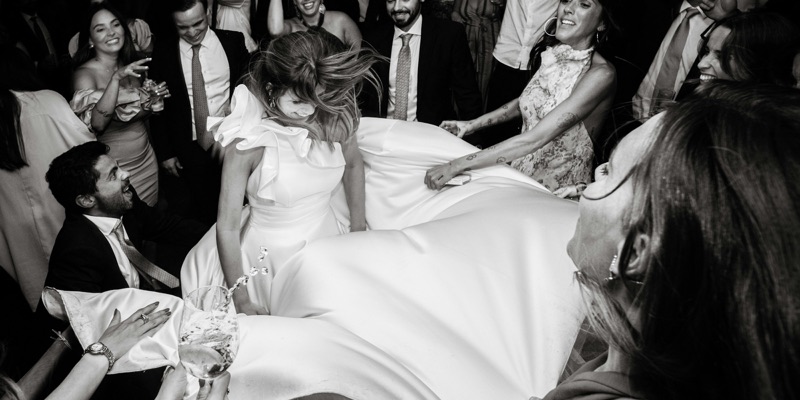 Wedding guests swirling the bride around a packed dancefloor