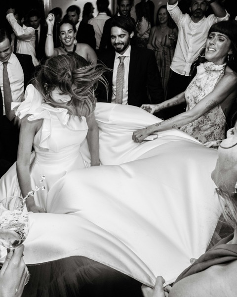 Wedding guests swirling the bride around the dancefloor