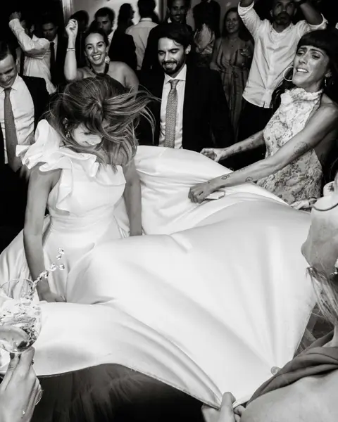 Wedding guests swirling the bride around the dancefloor